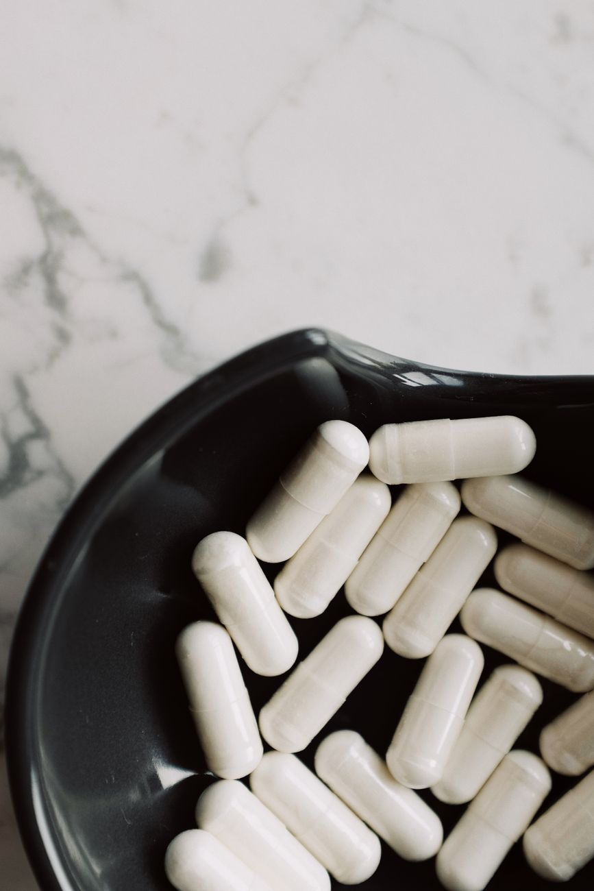 white medication capsules on black ceramic bowl